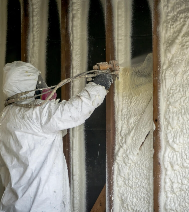 Canadian Insulation Experts technician spraying closed-cell foam insulation into a Toronto basement wall cavity