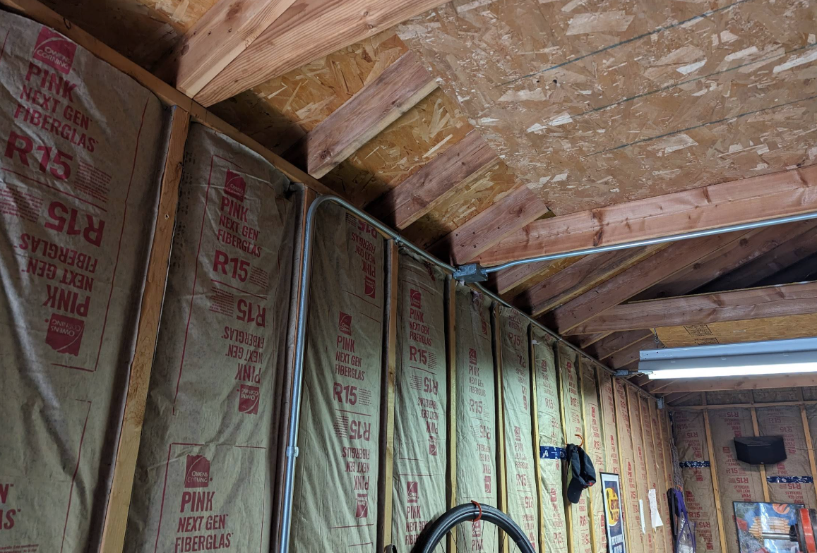 Garage interior with walls insulated in R15 fibreglass batts by Canadian Insulation Experts in Toronto