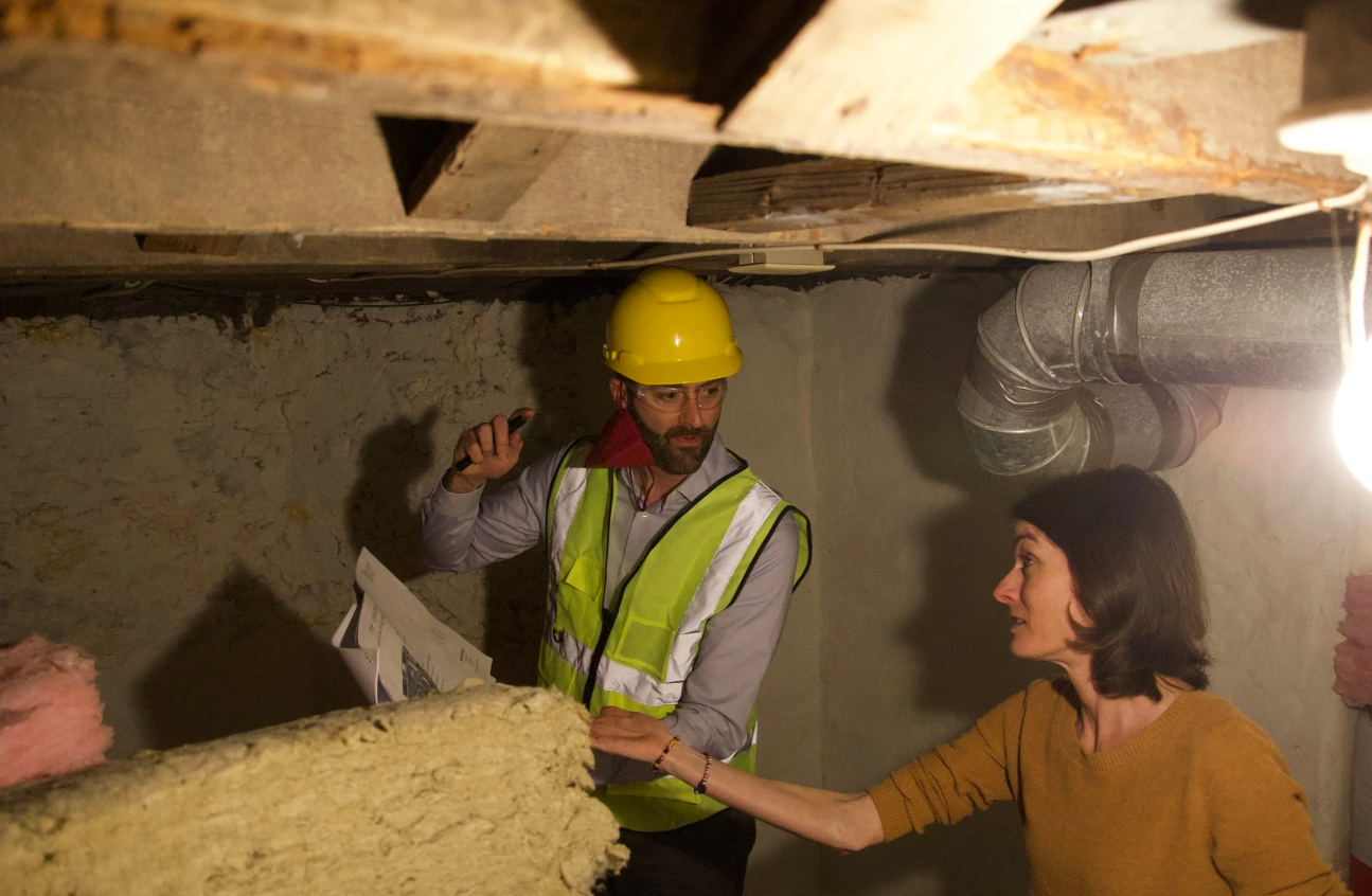 Canadian Insulation Experts technician assessing wall insulation with a homeowner during a free GTA energy audit