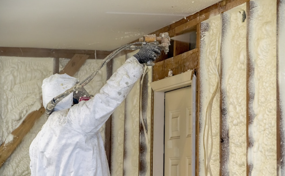 Canadian Insulation Experts technician spraying foam insulation into open wall studs in a GTA home